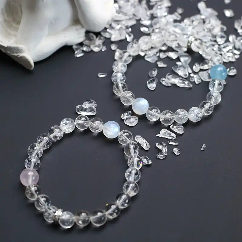 Aquamarine and white asai crystal beaded bracelet shown on open palm