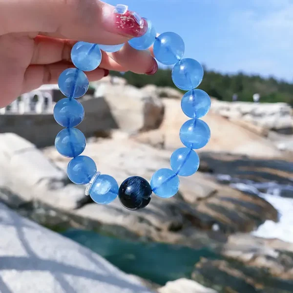 Crystal bracelet held up outdoors by the sea