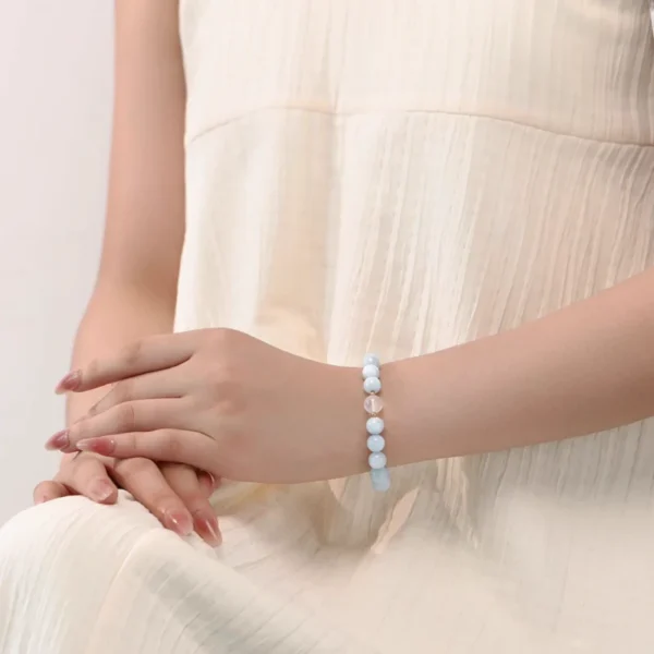 Model’s hands showing aquamarine bracelet with moonstone accent