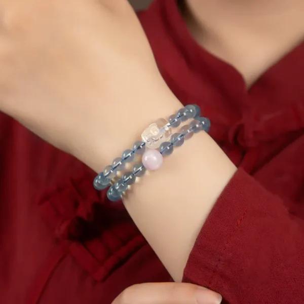 Woman wearing double-wrap Pixiu bracelet with aquamarine and rose quartz