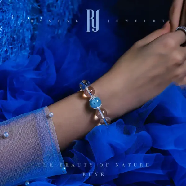 Model wearing blue crystal bracelet with aquamarine and clear quartz – elegant jewelry