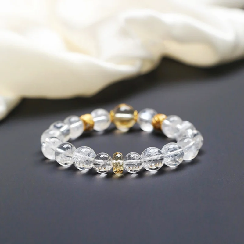 Clear quartz and citrine bracelet with gold accents on black background