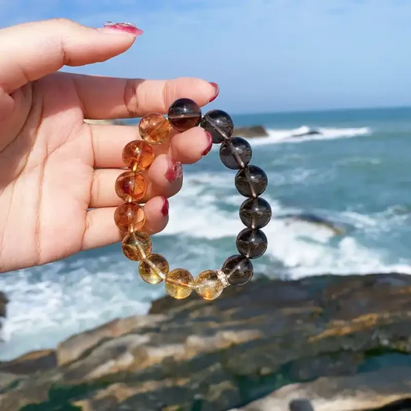 Hand holding spiritual energy bracelet with sea in background