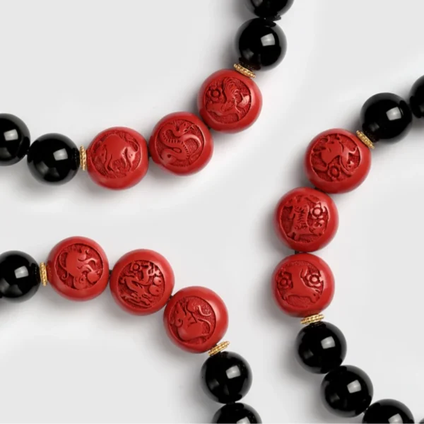 Close-up of Chinese zodiac cinnabar beads with obsidian bracelet