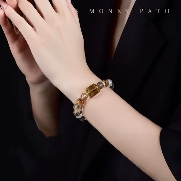 Holding golden wealth crystal bracelet in hand