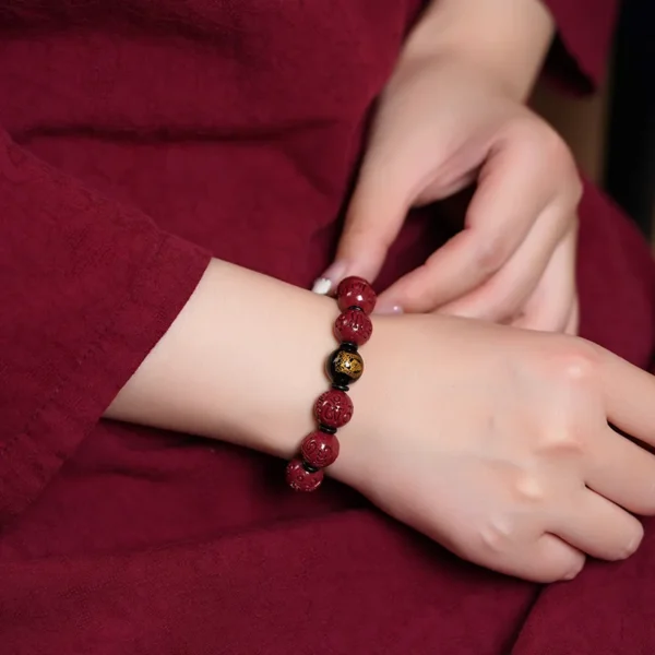 Woman wearing obsidian guardian Buddha bracelet with cinnabar beads