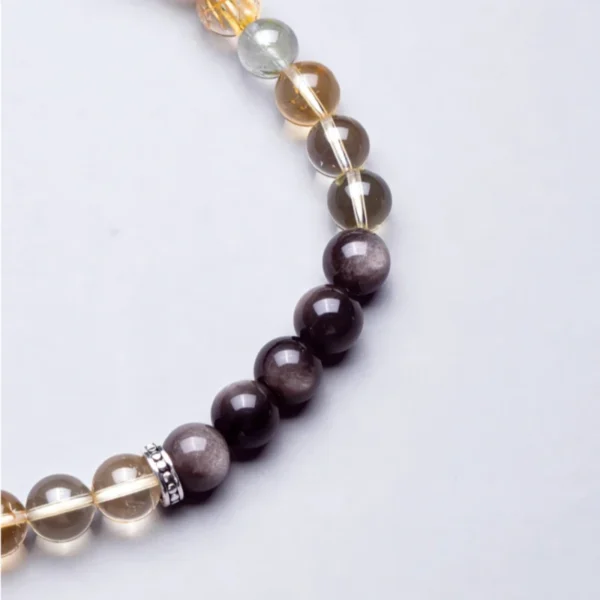 Detail of silver alloy charm with clear quartz and smoky crystal beads