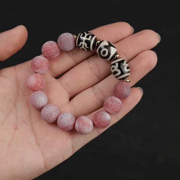 Close-up of Tibetan Dzi beads with cracked agate on palm