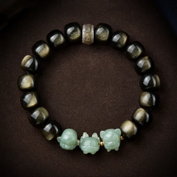 Trio of Hetian jade Pixiu charms in green jade color, set on a golden obsidian bracelet