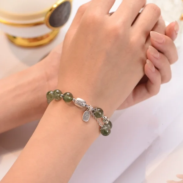 Woman wearing green rutilated quartz lucky bracelet