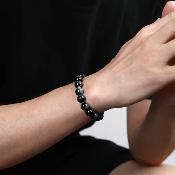 Man wearing Blue Tiger Eye bracelet with meditative posture