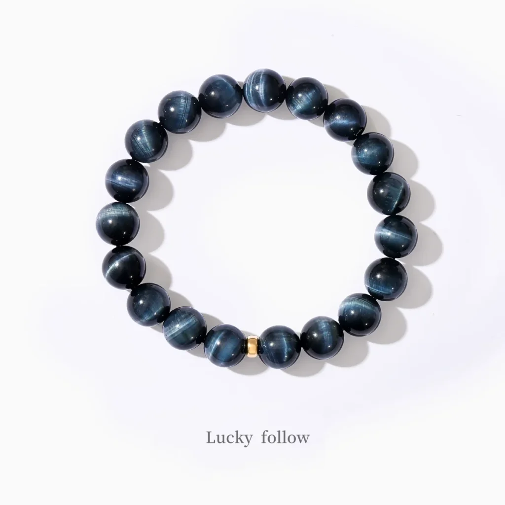 Blue Tiger Eye bracelet with golden accent on white background