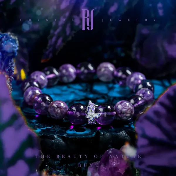 Amethyst and Charoite healing bracelet with silver butterfly charm on crystal background