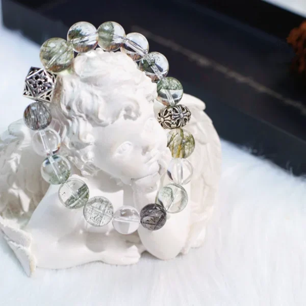 Green and clear crystal bracelet displayed on angel sculpture