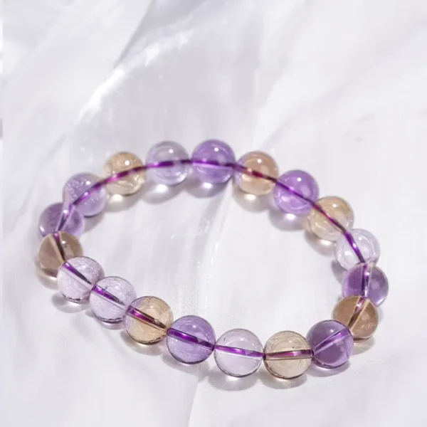 Amethyst and citrine bracelet resting against natural stone