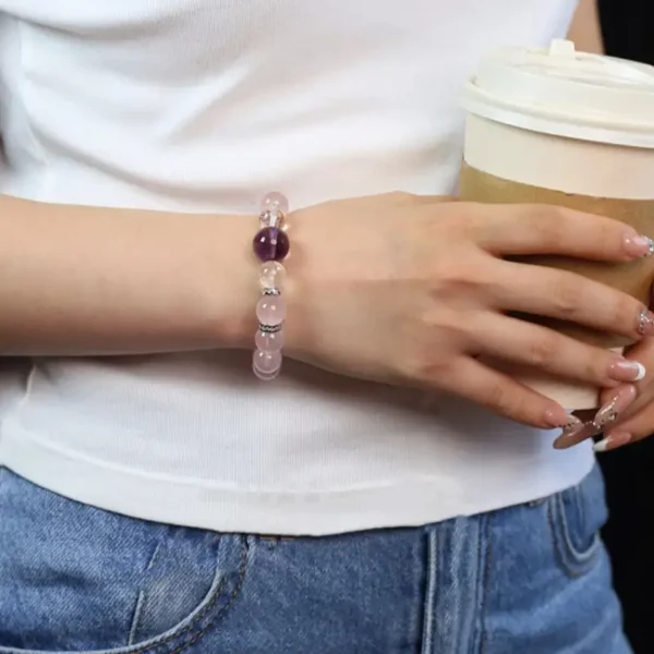 Hand wearing crystal love bracelet with coffee cup