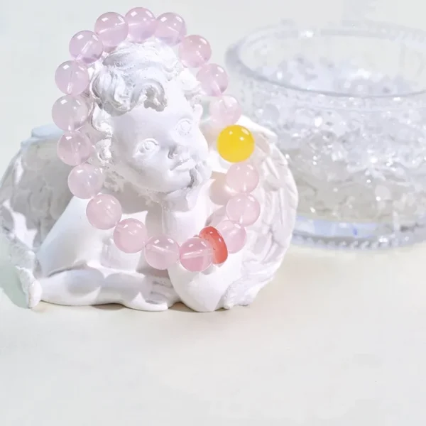 Rose quartz bracelet displayed on angel statue