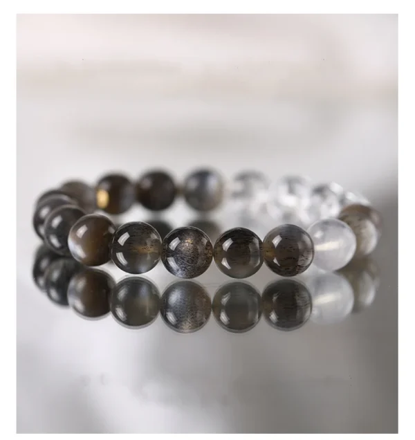 Black Gugan and Moonstone Healing Bracelet with Clear Quartz on reflective surface