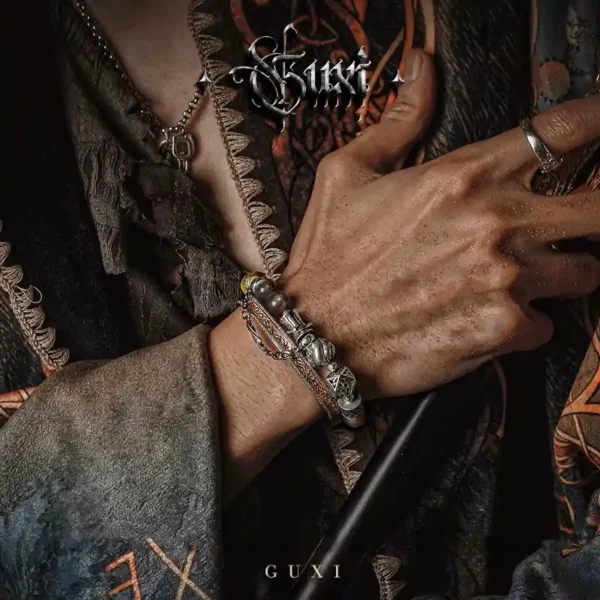 Close-up of GUXI bracelet stacked with chain and leather wristwear