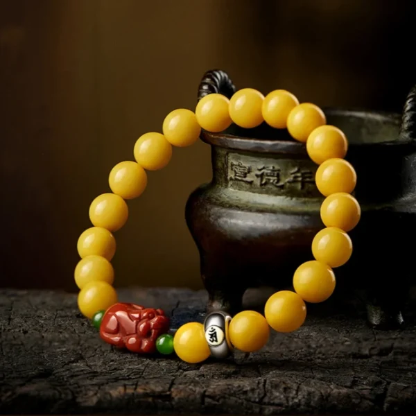 Beeswax amber and red agate Pixiu bracelet on antique background