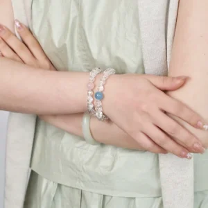 Layered crystal bracelets featuring aquamarine and white asai crystal