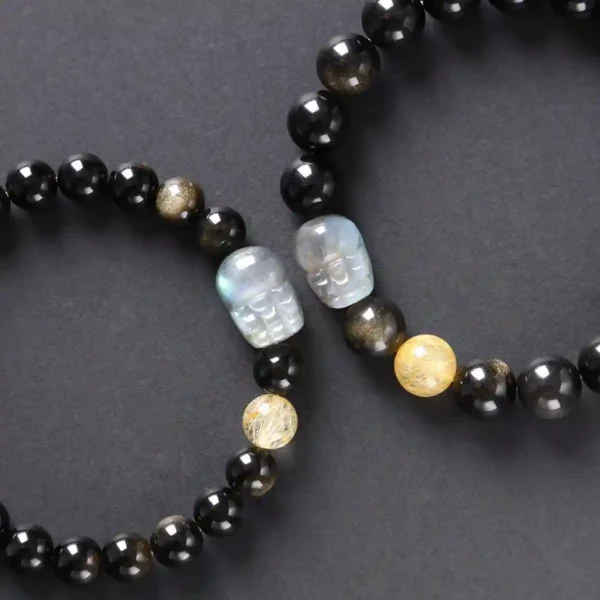 Upright display of obsidian crystal bracelet with moonstone Pixiu charm