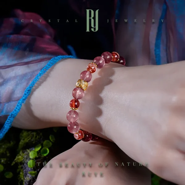 Holding Strawberry Quartz Bracelet in Hand with Gold Detailing