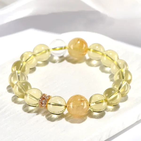 Citrine and Golden Rutilated Quartz wealth bracelet displayed on white ceramic plate