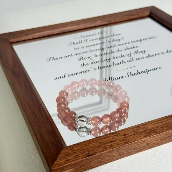 Strawberry and rose quartz crystal bracelet displayed on a Shakespeare mirror frame
