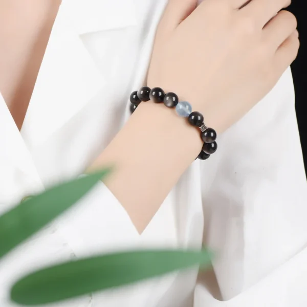 woman wearing obsidian and aquamarine bracelet