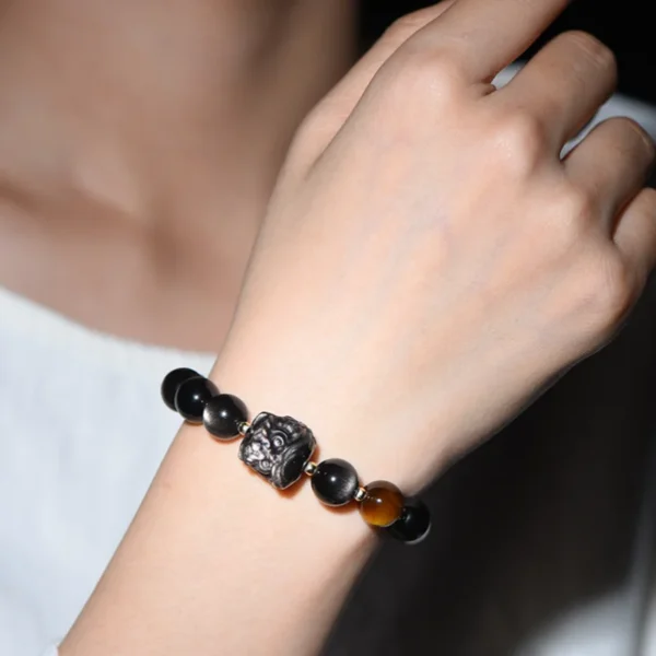 Wrist wearing silver obsidian bracelet with lion head center