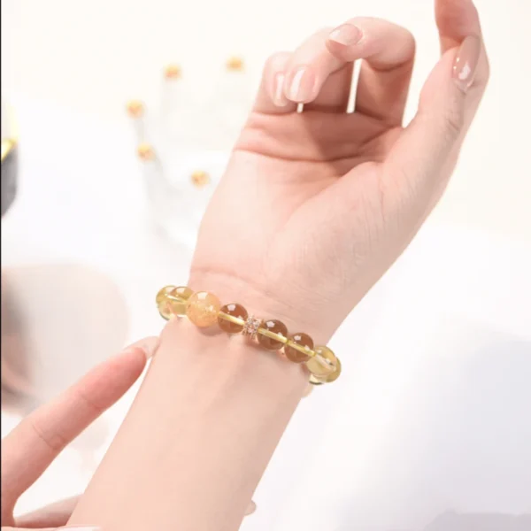 Model wearing golden crystal bracelet on wrist with clear sunlight