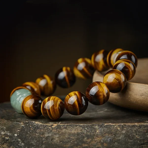 Close-up of a Yellow Tiger Eye bracelet with a green Hetian Jade Pixiu charm, showcasing its natural luster and craftsmanship.