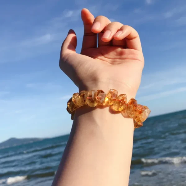 Yellow topaz bracelet worn on wrist with sea background