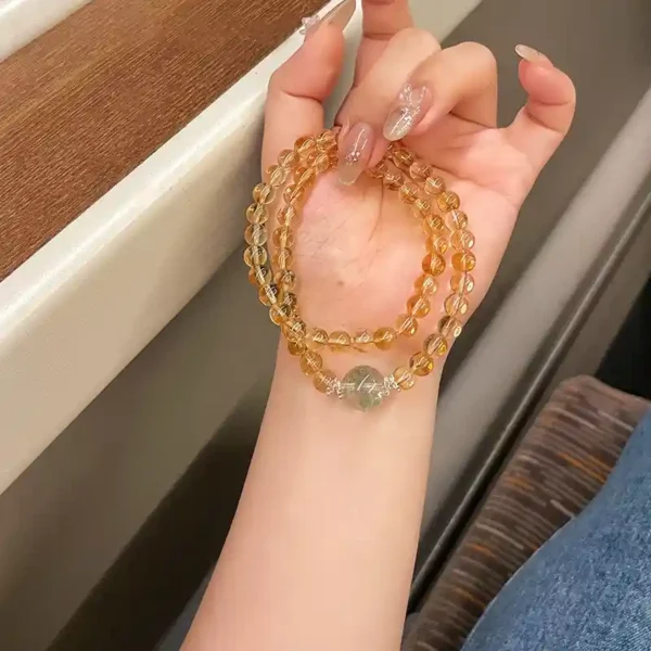 Hand holding the Prosperity Flow bracelet on train windo